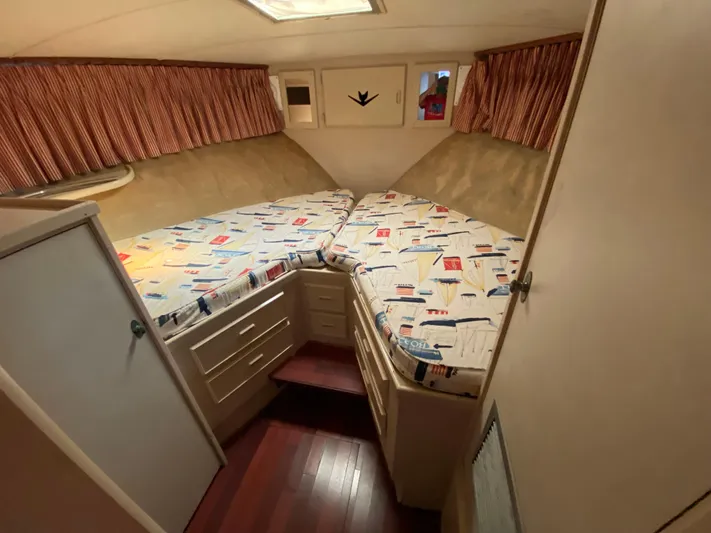 Yacht Photos Pics 1982 Bertram 46.6 War Wagon cabin interior with twin beds and nautical-themed bedding.
