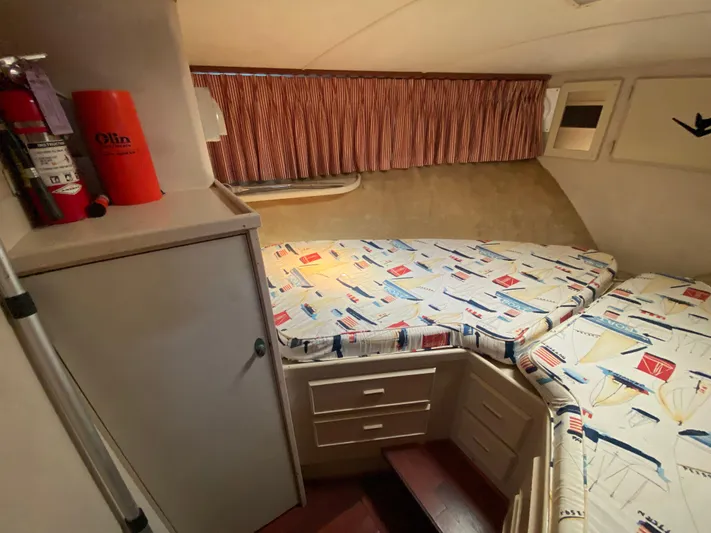  Yacht Photos Pics Cozy cabin interior of 1982 Bertram 46.6 War Wagon with nautical-themed bedding.