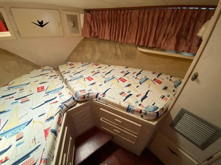  Yacht Photos Pics Cozy cabin interior of 1982 Bertram 46.6 War Wagon with nautical-themed bedding.
