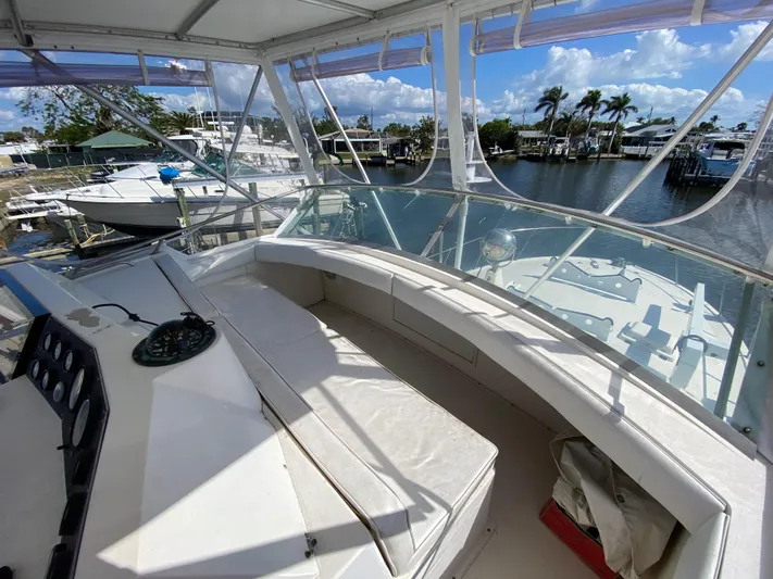  Yacht Photos Pics 1982 Bertram 46.6 War Wagon boat interior with seating, docked near palm trees and water.