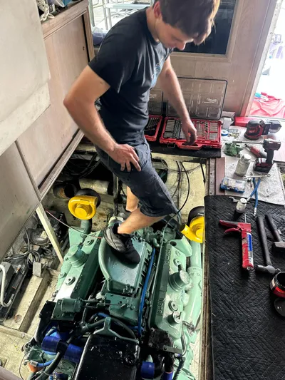  Yacht Photos Pics Man working on engine of 1982 Bertram 46.6 War Wagon boat.