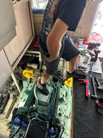  Yacht Photos Pics Man working on engine of 1982 Bertram 46.6 War Wagon boat.