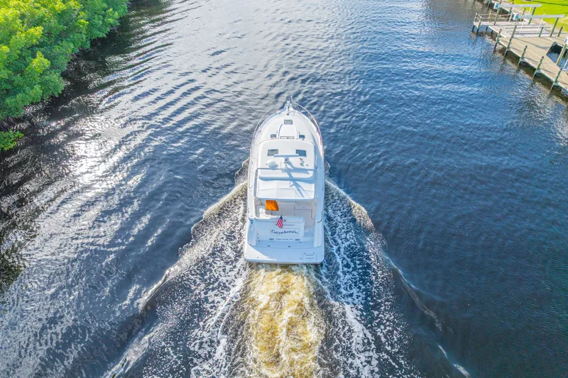  Yacht Photos Pics Aerial view of 2011 Tiara Yachts 4300 Sovran cruising on a serene waterway.