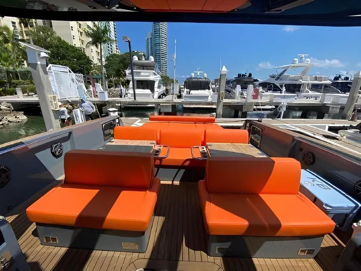 One Love Yacht Photos Pics Luxurious 2019 Fjord 52 Open yacht with vibrant orange seating at a marina.