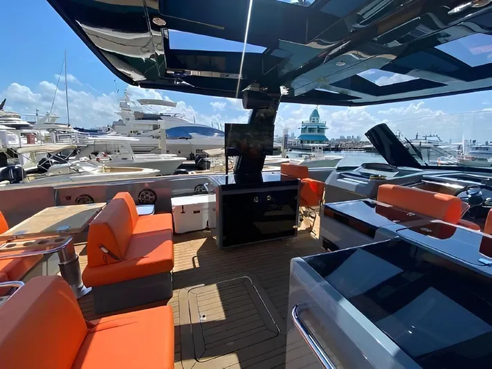 One Love Yacht Photos Pics Luxurious 2019 Fjord 52 Open yacht interior with orange seating and modern amenities at a marina.