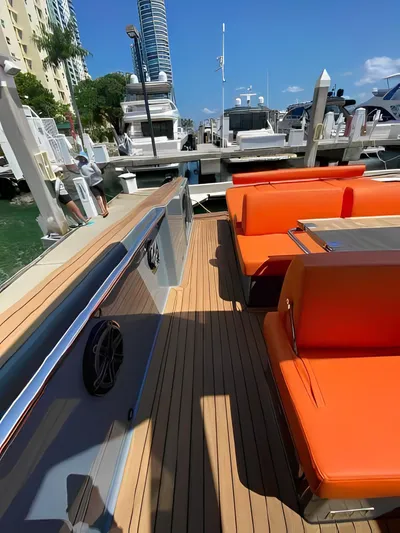 One Love Yacht Photos Pics 2019 Fjord 52 Open yacht with orange seating at a marina.
