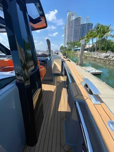 One Love Yacht Photos Pics 2019 Fjord 52 Open yacht docked, featuring sleek design and modern architecture in the background.