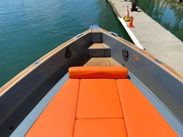 One Love Yacht Photos Pics 2019 Fjord 52 Open boat with orange seating, docked by a pier.