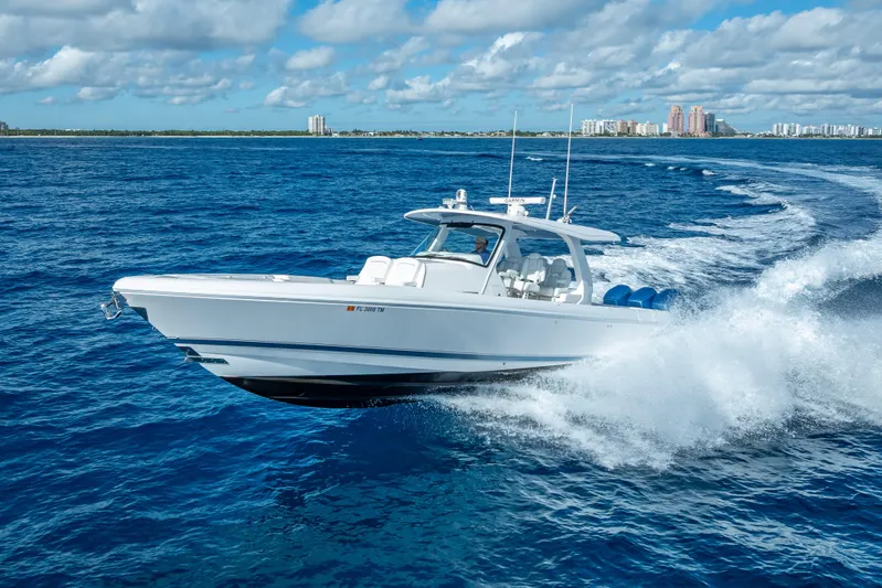  Yacht Photos Pics 2023 Intrepid 427 Nomad SE cruising on open ocean with city skyline in background.