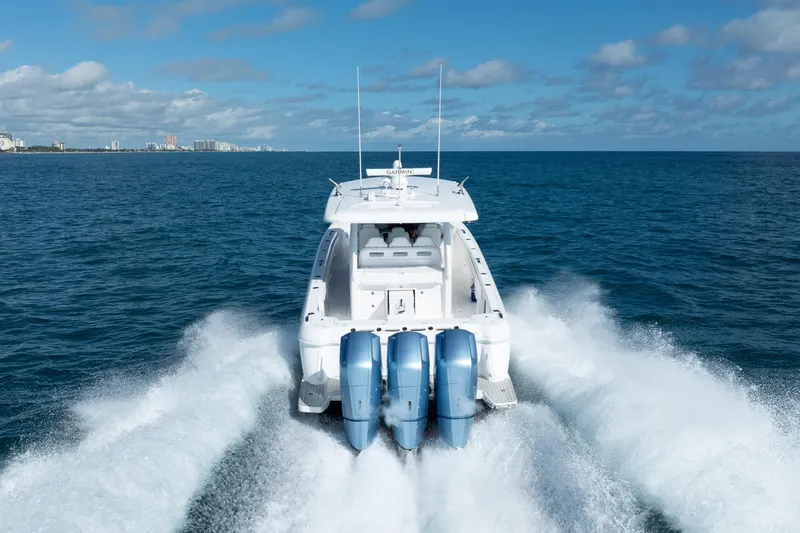  Yacht Photos Pics 2023 Intrepid 427 Nomad SE cruising on open ocean with city skyline in background.