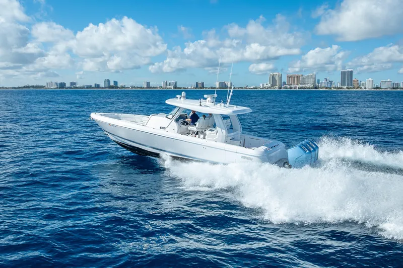  Yacht Photos Pics 2023 Intrepid 427 Nomad SE cruising on ocean with city skyline in background.