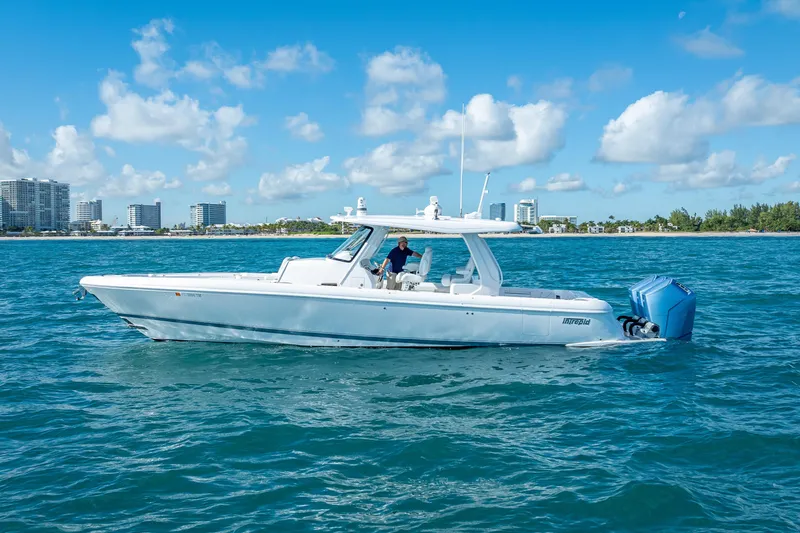  Yacht Photos Pics 2023 Intrepid 427 Nomad SE boat cruising on blue ocean near city skyline.