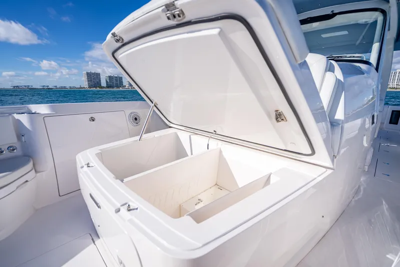  Yacht Photos Pics 2023 Intrepid 427 Nomad SE boat with open storage compartment, ocean view background.