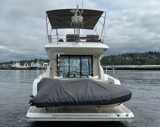 R & R Yacht Photos Pics Prestige 420 yacht, 2015 model, docked with covered equipment, scenic waterfront background.