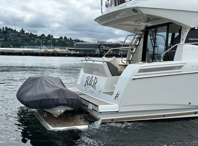 R & R Yacht Photos Pics Prestige 420 yacht, 2015 model, docked with covered dinghy on water.