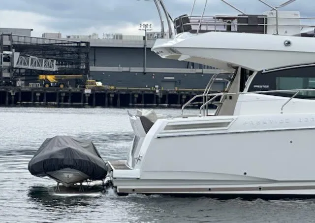 R & R Yacht Photos Pics Prestige 420 yacht from 2015 docked with covered dinghy, industrial backdrop.