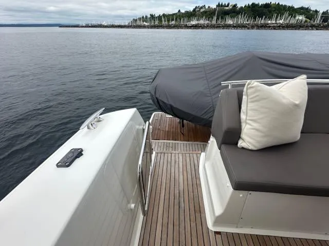 R & R Yacht Photos Pics Luxury 2015 Prestige 420 yacht deck with seating, overlooking calm waters and distant marina.