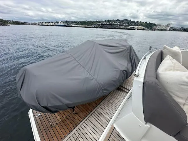 R & R Yacht Photos Pics Covered boat on Prestige 420 yacht deck, overlooking calm waters and distant shoreline.