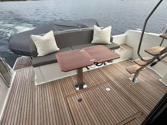 R & R Yacht Photos Pics Prestige 420 yacht deck with wooden flooring, cushioned seating, and table, 2015 model.