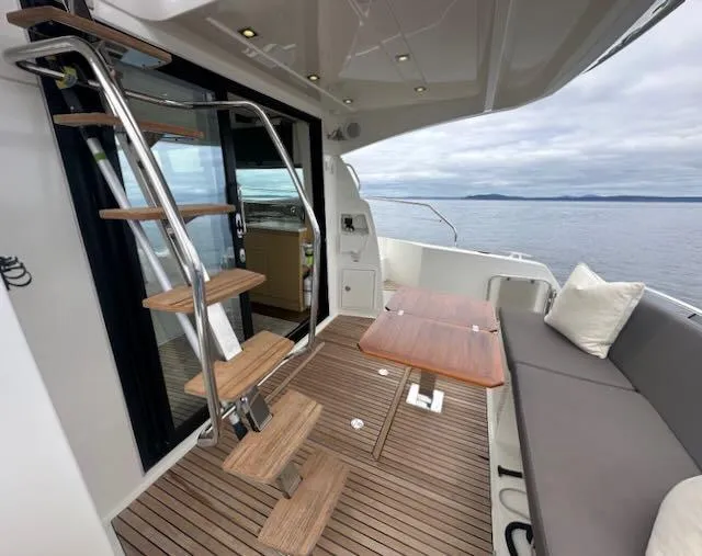 R & R Yacht Photos Pics Luxurious 2015 Prestige 420 yacht deck with seating, table, and stairs, overlooking serene ocean view.