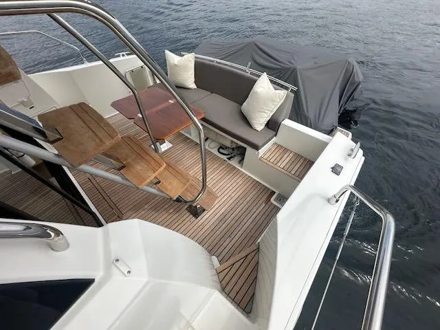 R & R Yacht Photos Pics Luxurious 2015 Prestige 420 yacht deck with seating and wooden table on water.