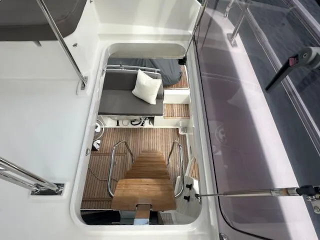 R & R Yacht Photos Pics Interior view of a 2015 Prestige 420 yacht, featuring wooden steps and cushioned seating.