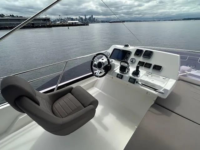 R & R Yacht Photos Pics Flybridge of 2015 Prestige 420 yacht with helm station overlooking calm waters.