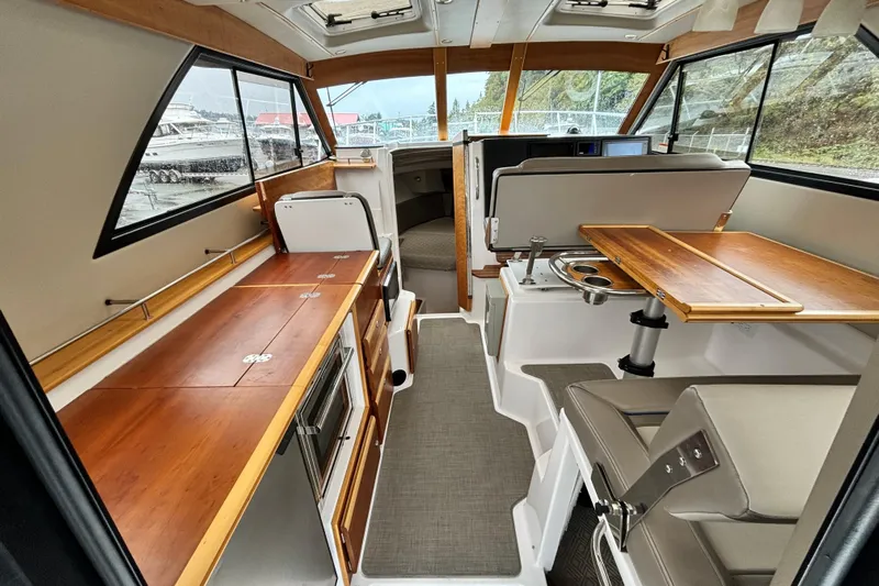  Yacht Photos Pics 2019 Cutwater C-302 Coupe interior with wood finishes and seating area.