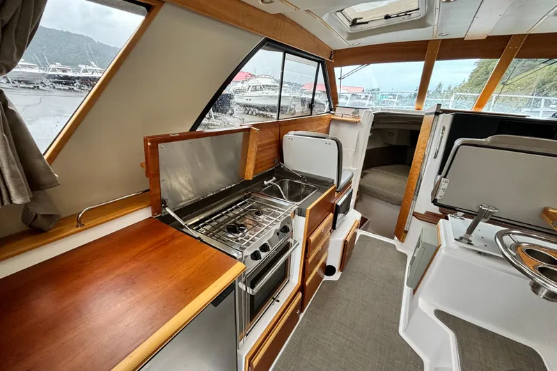  Yacht Photos Pics 2019 Cutwater C-302 Coupe interior with kitchen, sink, and seating area.
