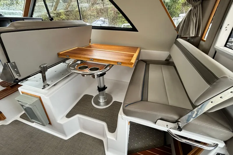  Yacht Photos Pics 2019 Cutwater C-302 Coupe interior with foldable table and cushioned seating.