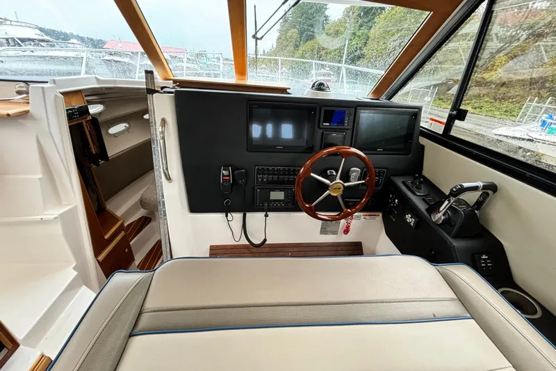  Yacht Photos Pics 2019 Cutwater C-302 Coupe helm with modern controls and wooden steering wheel.