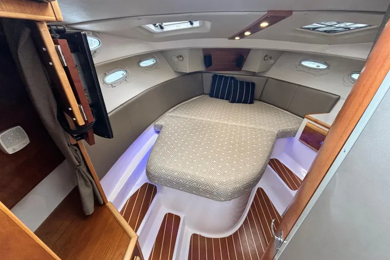  Yacht Photos Pics 2019 Cutwater C-302 Coupe cabin interior with cozy bed and wooden accents.