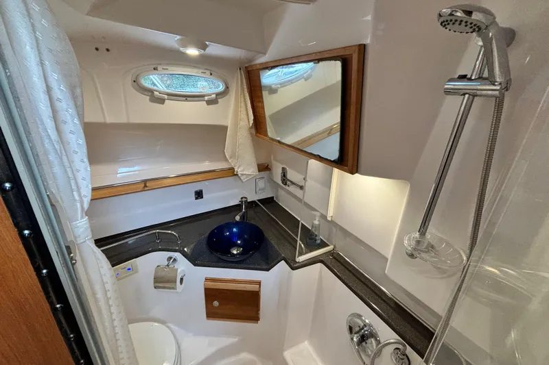  Yacht Photos Pics 2019 Cutwater C-302 Coupe bathroom with shower, sink, and mirror.