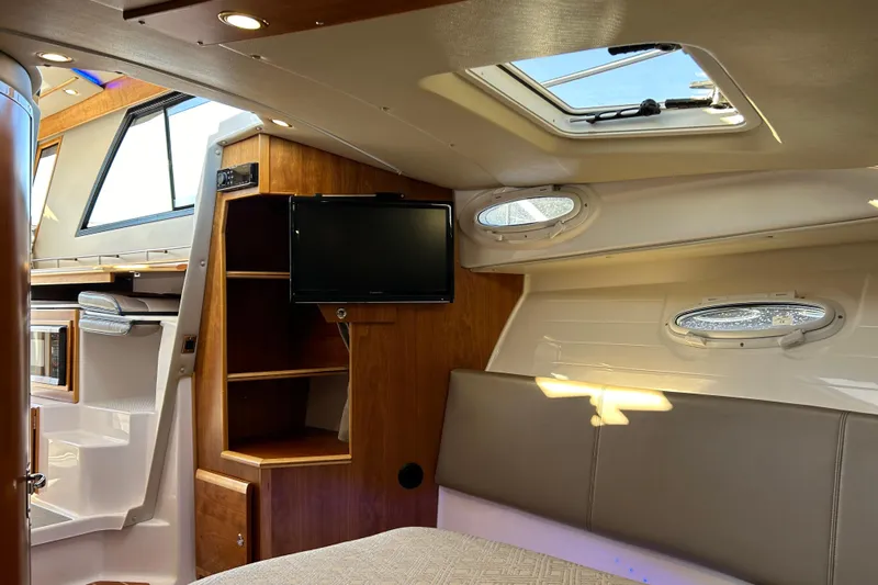  Yacht Photos Pics 2019 Cutwater C-302 Coupe interior with wood accents, TV, and skylight.