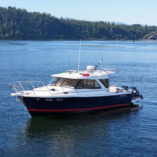  Yacht Photos Pics 2019 Cutwater C-302 Coupe boat on a serene lake with forested hills.