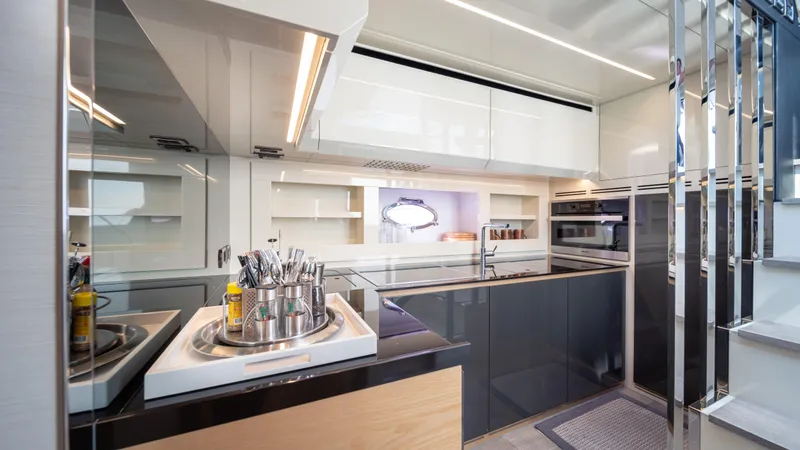 "liquid" Yacht Photos Pics Modern kitchen interior on a 2020 Pershing 70 yacht, featuring sleek cabinetry and stainless steel appliances.