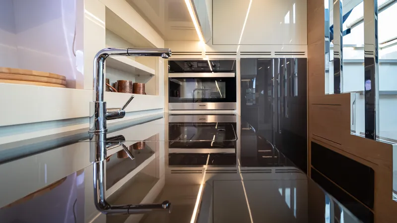 "liquid" Yacht Photos Pics Modern kitchen interior on a 2020 Pershing 70 yacht, featuring sleek countertops and built-in appliances.