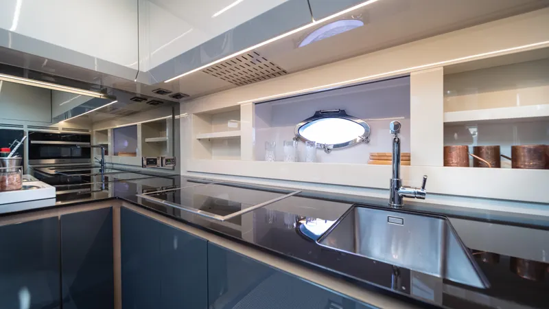 "liquid" Yacht Photos Pics Modern kitchen interior on a 2020 Pershing 70 yacht, featuring sleek design and stainless steel appliances.