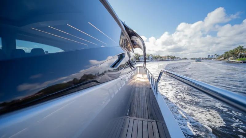 "liquid" Yacht Photos Pics Sleek 2020 Pershing 70 yacht cruising on a sunny day, reflecting blue skies and water.
