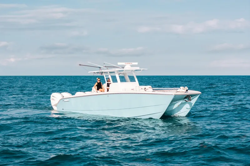  Yacht Photos Pics 2021 Invincible 37 Catamaran cruising on open sea under clear skies.