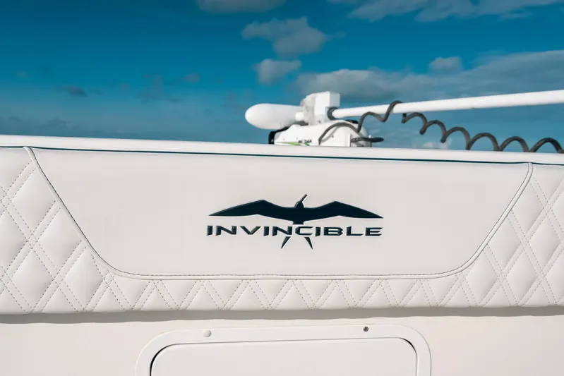  Yacht Photos Pics Invincible 37 Catamaran 2021 logo on white quilted upholstery against blue sky.