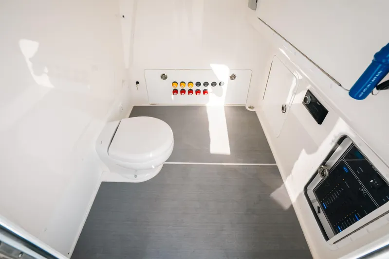  Yacht Photos Pics Interior of 2021 Invincible 37 Catamaran featuring a compact marine toilet and control panel.