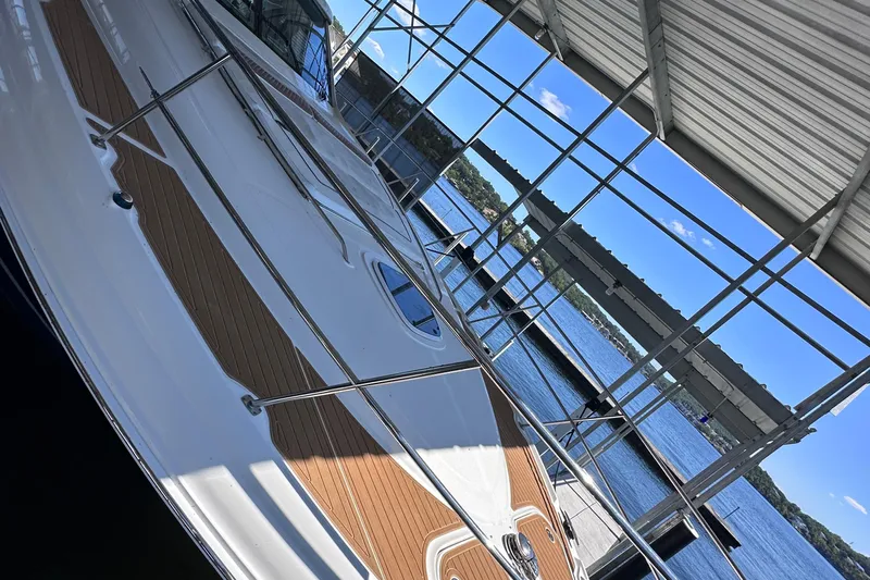  Yacht Photos Pics 2005 Sea Ray 48 Sundancer yacht docked under a covered marina with scenic lake view.