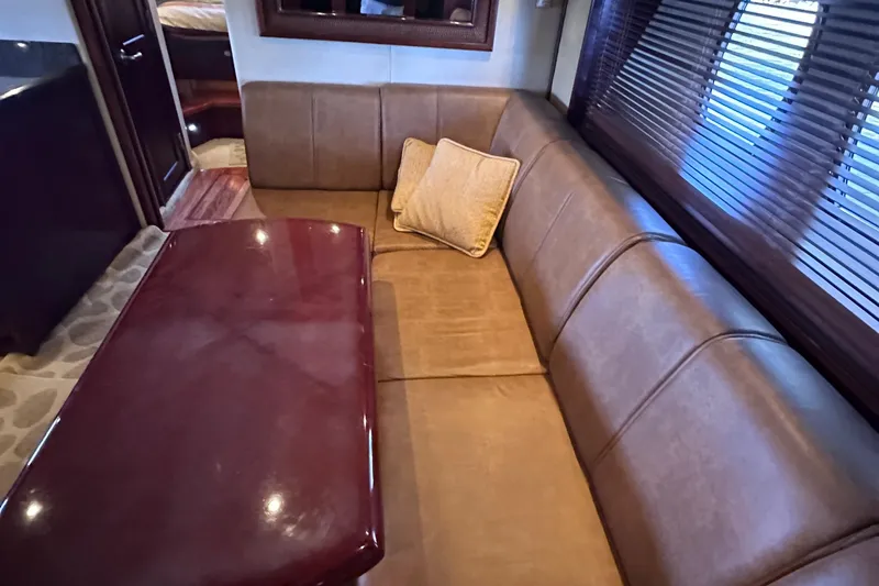  Yacht Photos Pics Luxurious interior of 2005 Sea Ray 48 Sundancer yacht with leather seating and wooden table.