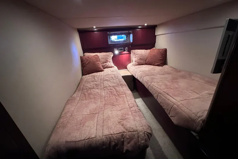  Yacht Photos Pics Cozy twin cabin in 2005 Sea Ray 48 Sundancer yacht, featuring plush bedding and ambient lighting.