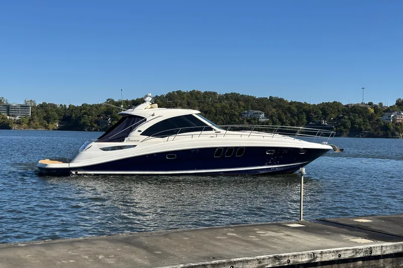  Yacht Photos Pics 2005 Sea Ray 48 Sundancer yacht on a calm lake with scenic background.