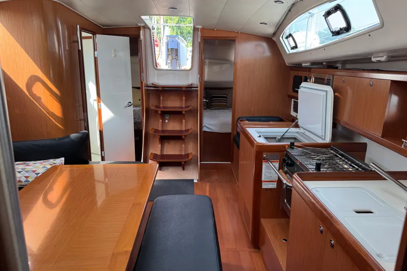 Eos Yacht Photos Pics Interior of 2008 Beneteau Oceanis 40 sailboat, featuring wood finish, kitchen, and seating area.