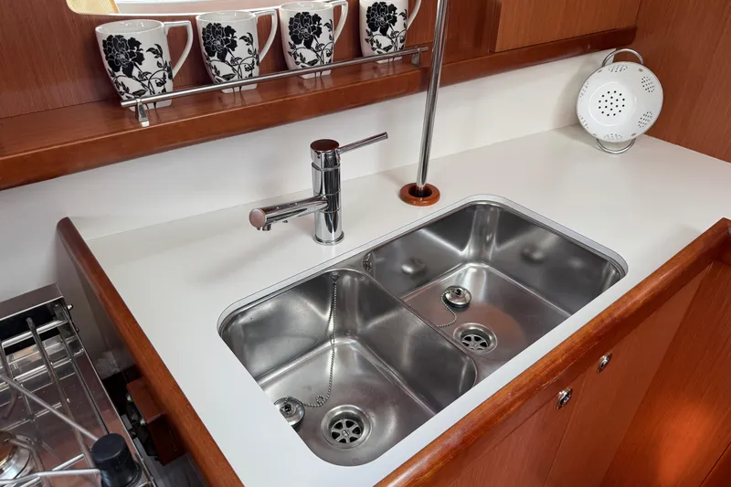 Eos Yacht Photos Pics Modern kitchen sink in 2008 Beneteau Oceanis 40 yacht, featuring dual basins and elegant faucet.