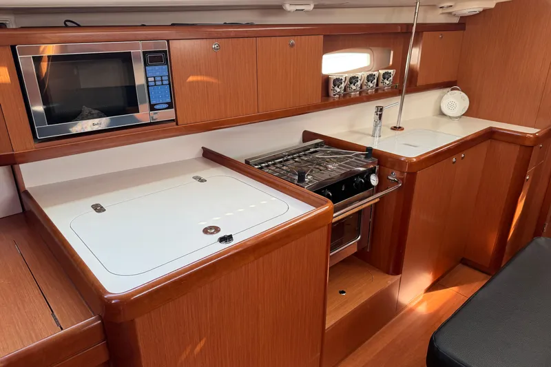 Eos Yacht Photos Pics 2008 Beneteau Oceanis 40 yacht kitchen with microwave, stove, and wooden cabinetry.