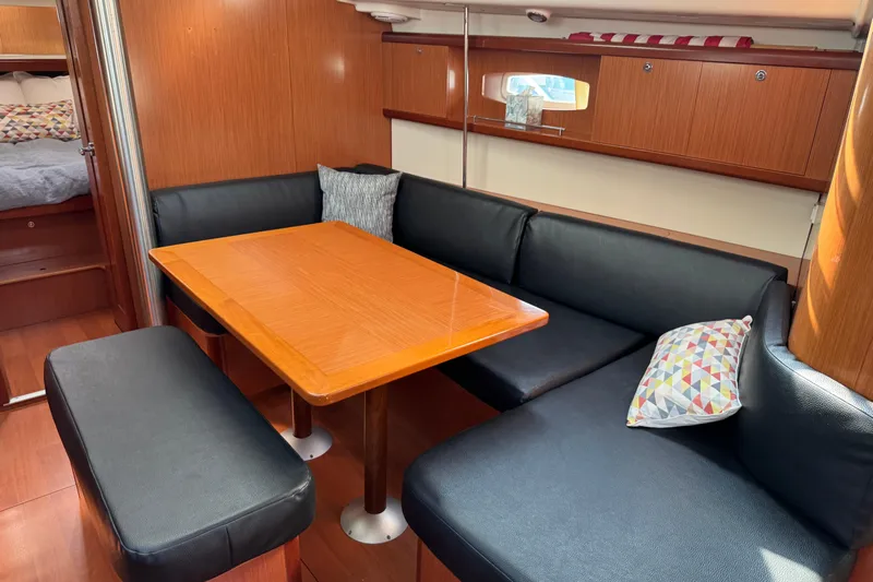 Eos Yacht Photos Pics Interior of 2008 Beneteau Oceanis 40 yacht with cozy dining area and wooden table.